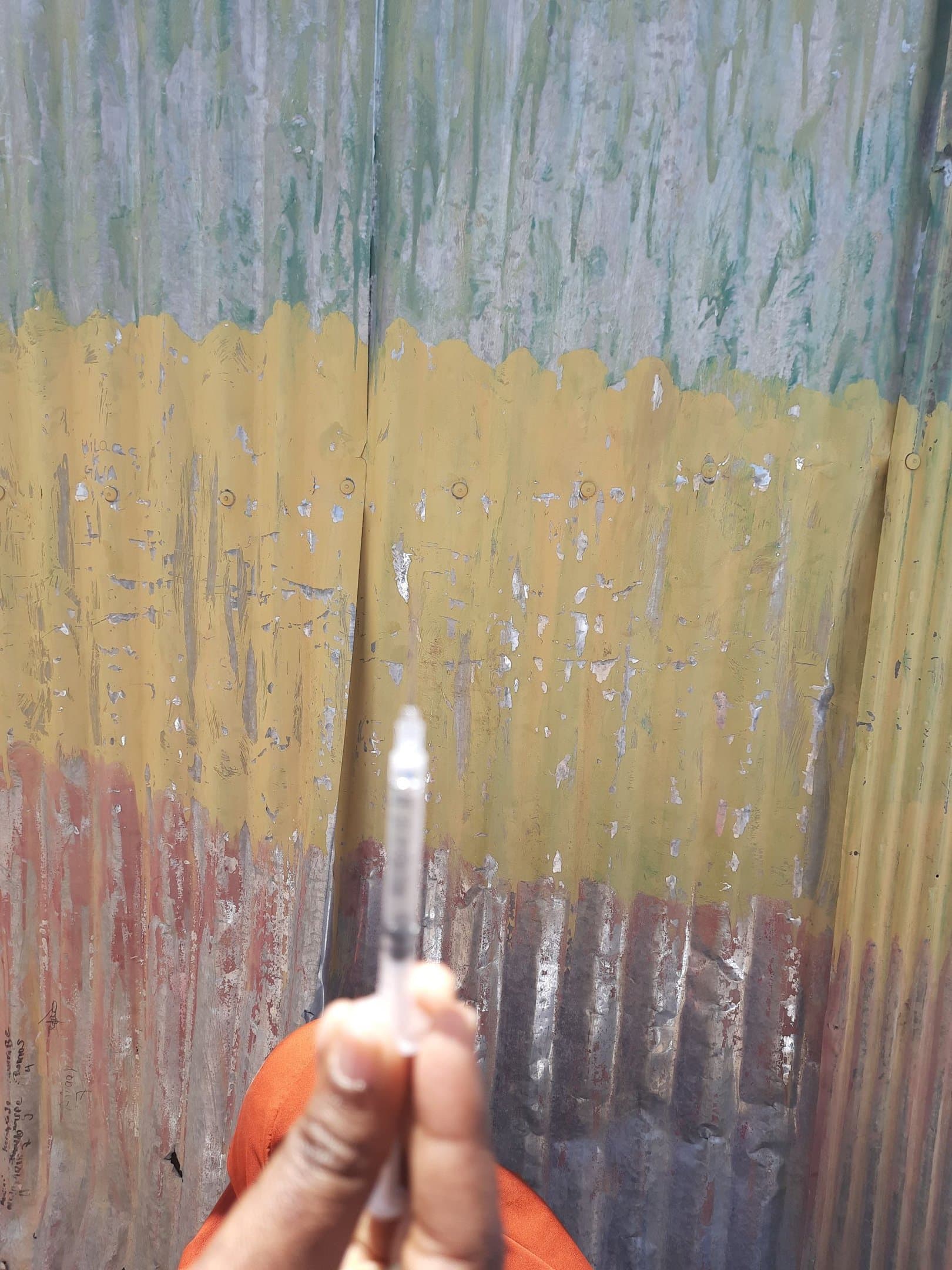 A SHIFA health worker preparing a vaccine syringe during a field immunization campaign