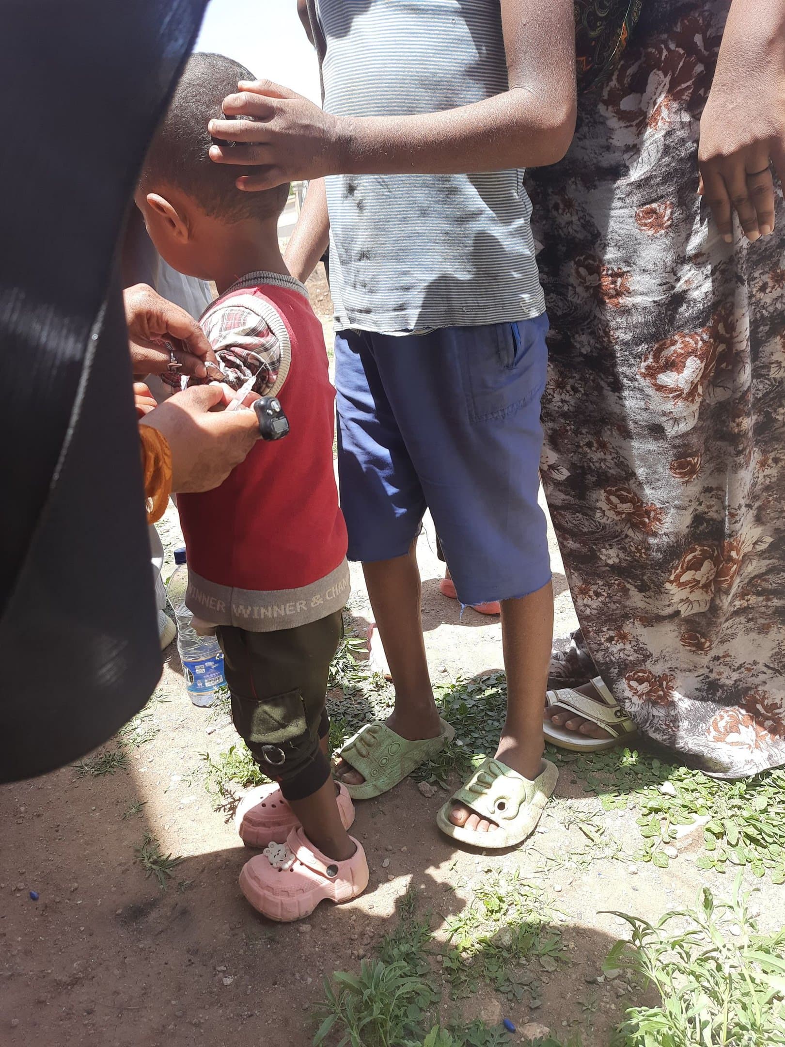 A SHIFA health worker vaccinating a child during a community immunization campaign